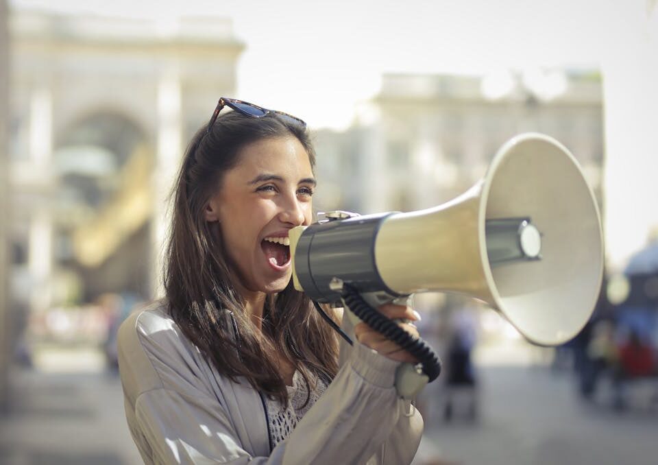 Audio Marketing: o que é e como implementar em sua entrega mulher jovem realizando audio marketing
