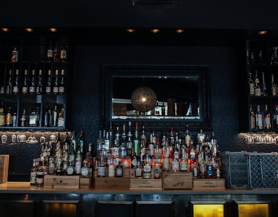 Estoque sempre em dia: apps que ajudam bares e restaurantes Explore a stylish bar interior showcasing an array of liquor bottles on shelves.