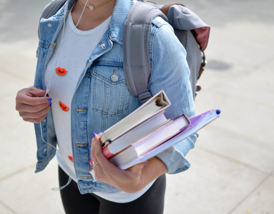 Livros e materiais de estudo: como comprar de forma eficiente woman wearing blue denim jacket holding book