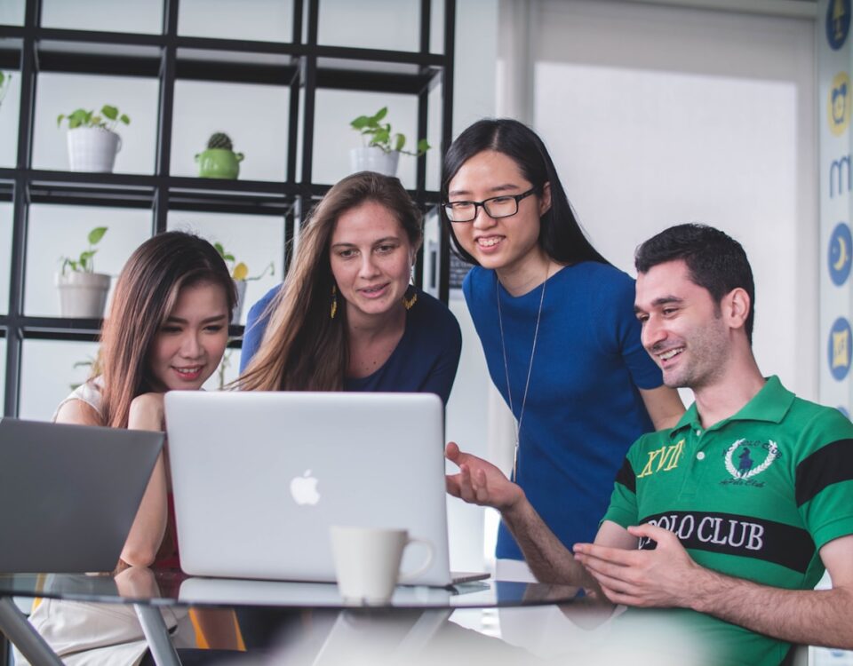 Como a confiança impacta vendas no mundo digital four people watching on white MacBook on top of glass-top table