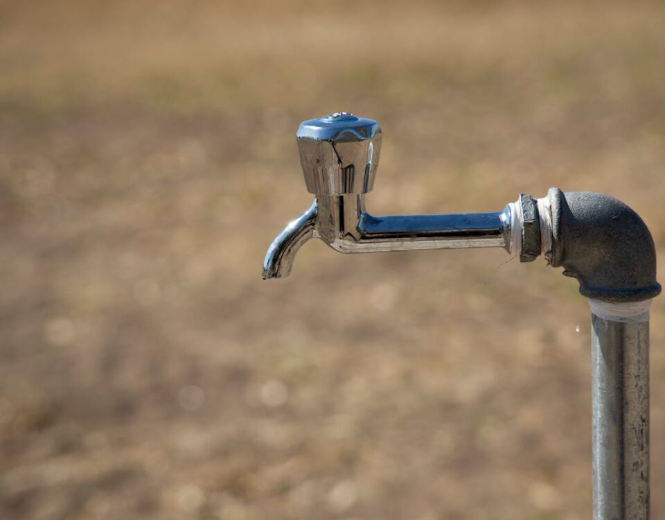 Equipamentos para vazamentos: Onde comprar confiável Close-up of a metal water faucet in an outdoor setting, highlighting its rustic charm and simplicity.