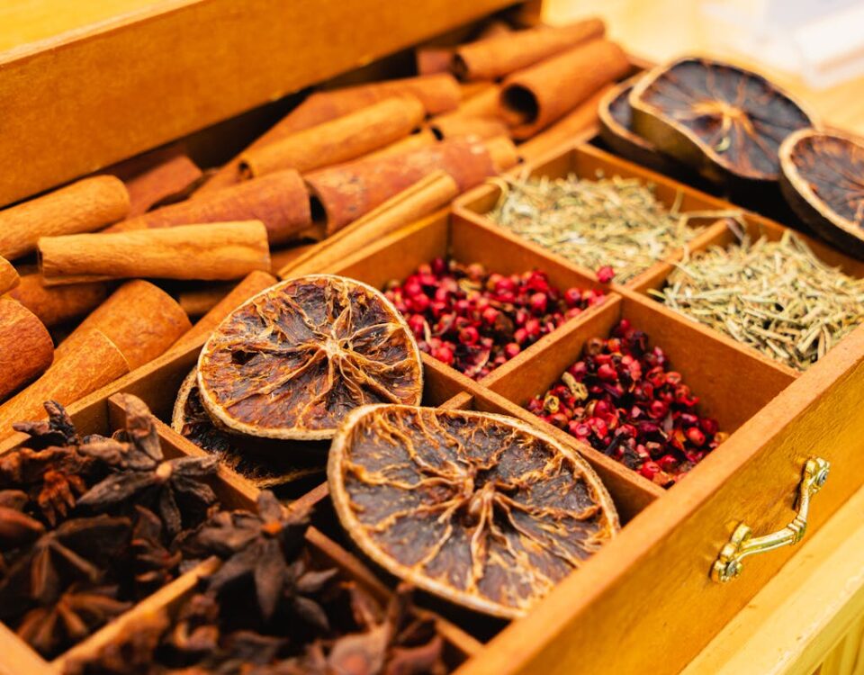 Como escolher ingredientes online sem surpresas A wooden box filled with assorted spices and dried citrus slices, showcasing natural flavors.