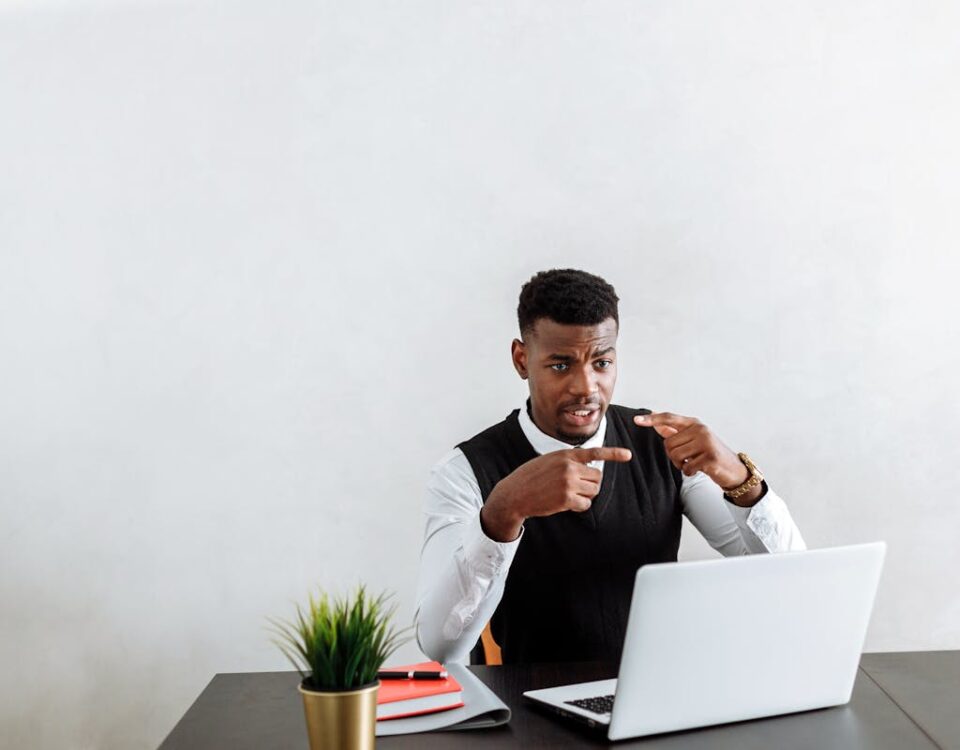 Cuidados ao contratar advogados de saúde em marketplaces Professional businessman explaining during video call using laptop in modern office setting.