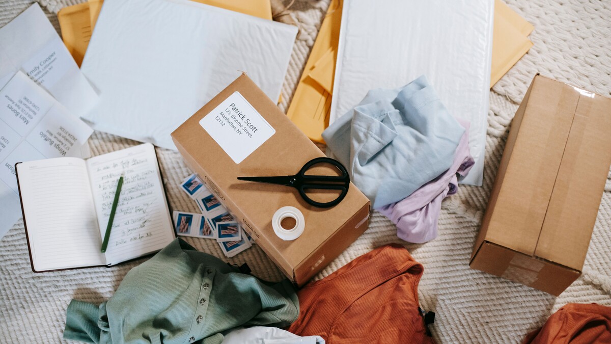 Materiais de embalagem, caixas e roupas organizados para envio