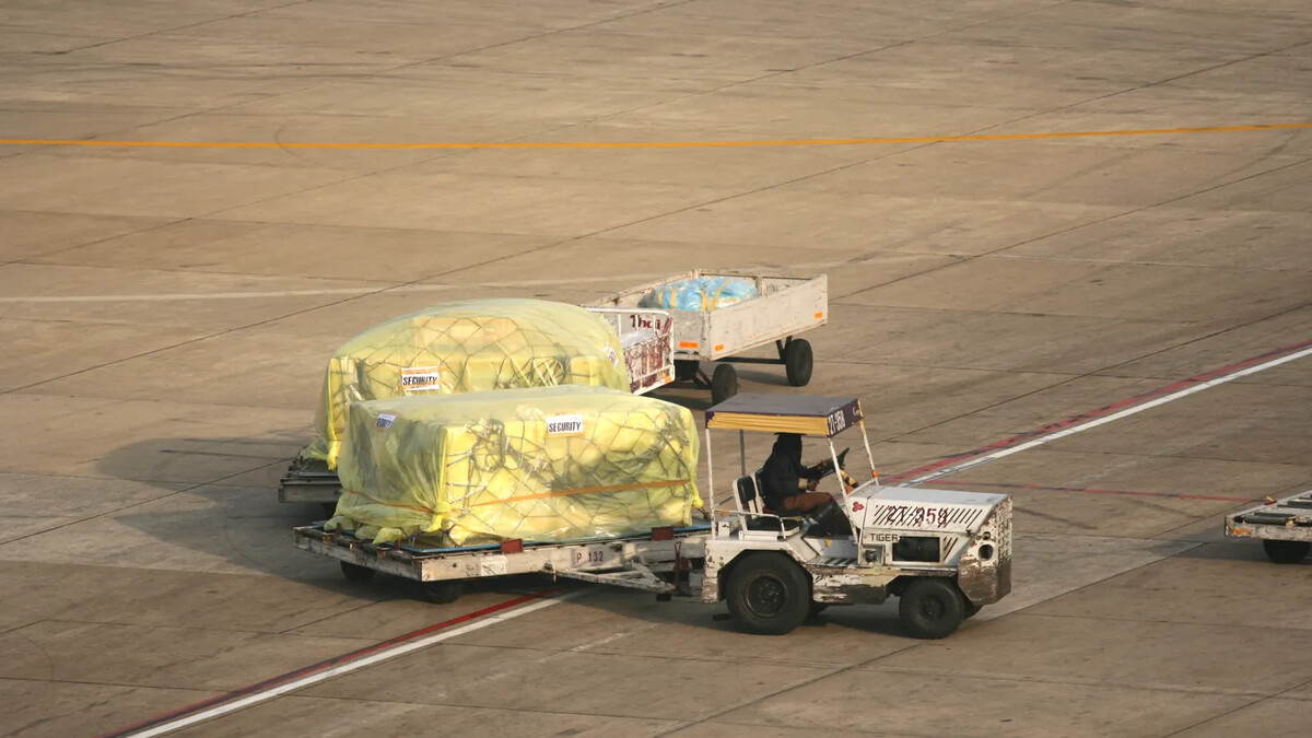 Vista aérea de carga sendo movimentada na pista de um aeroporto
