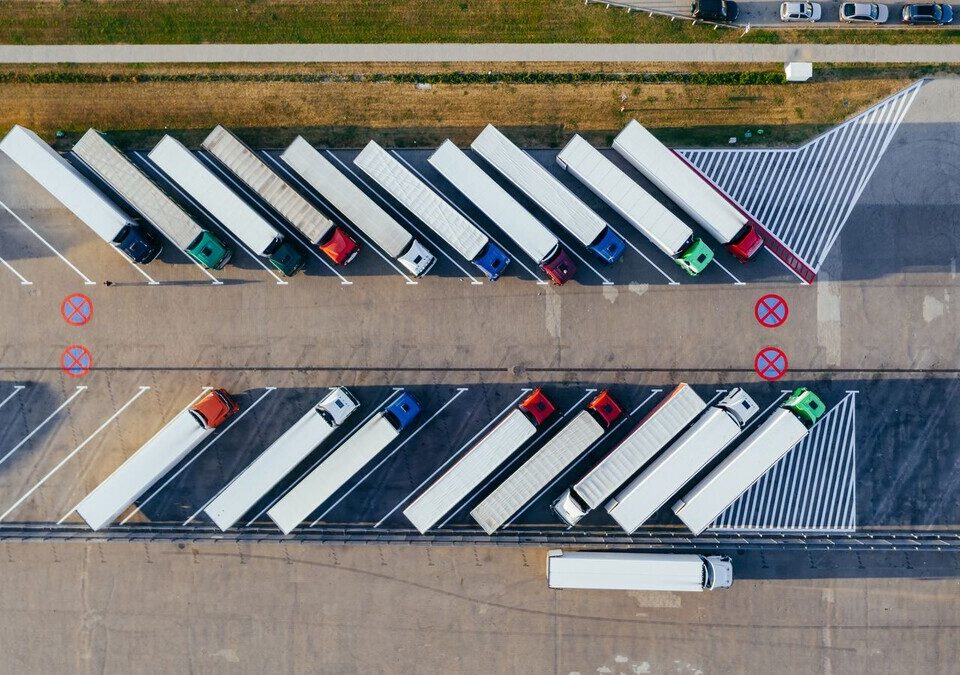 Vista aérea de caminhões estacionados em um pátio de transportadora