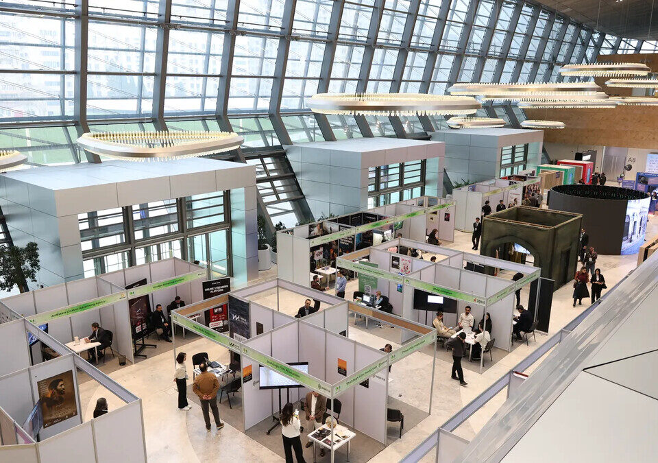 Pavilhão de feira de negócios com estandes e visitantes